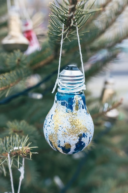 Painted old electric light bulb on Christmas tree DIY decoration