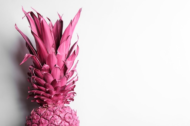 Painted pink pineapple on white background top view Creative concept