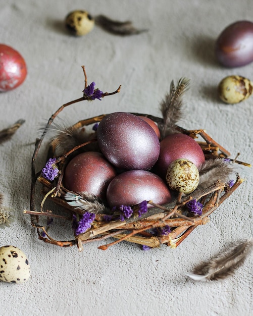 Painted purple easter eggs in a nest on a white background