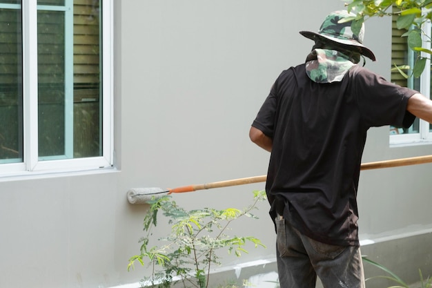 A painter is painting over the old paint for a housing estate