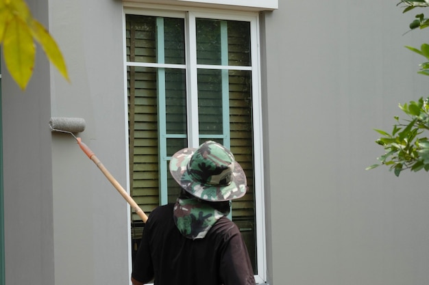 A painter is painting over the old paint for a housing estate