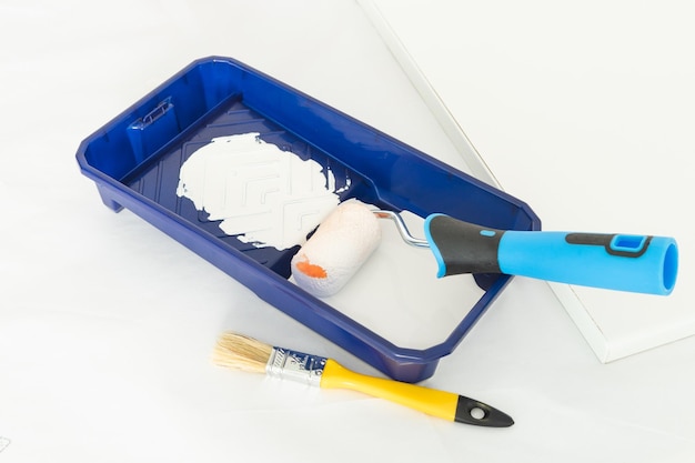 Painter's utensils Roller brush and tray with white paint Copy space