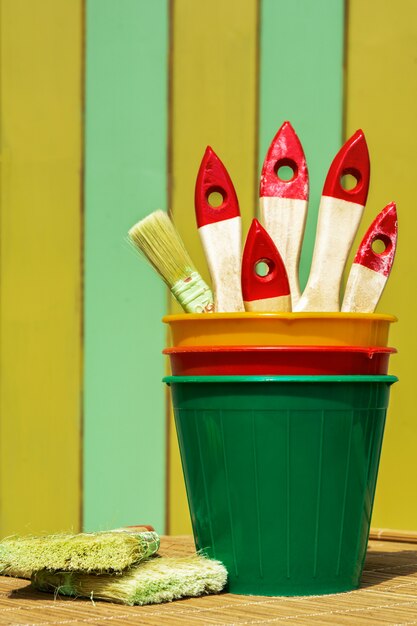 Painting brushes in pots against the painted wall