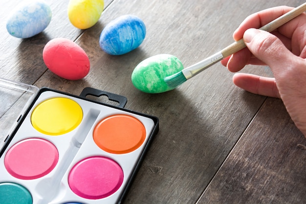 Painting Colorful Easter eggs on wooden table