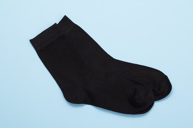 Pair of black warm men socks on a blue background, Top view.