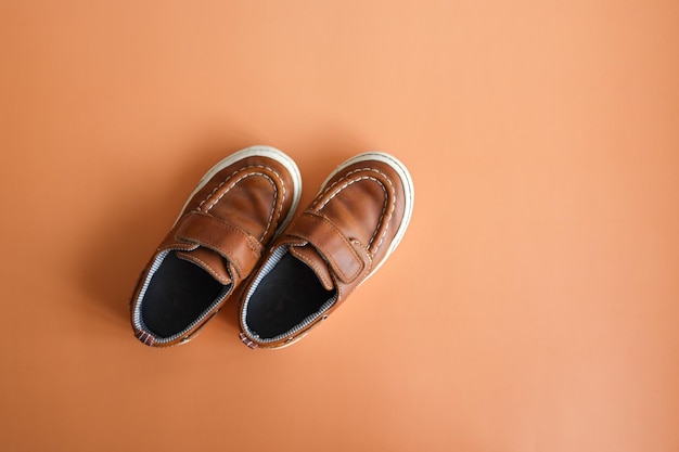 Pair of brown boy's shoes on colorful background Top view