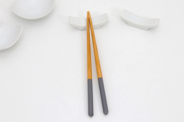 A pair of chopsticks with a white bird on the top.