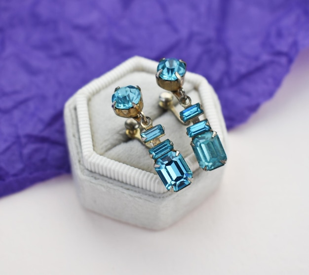 Photo a pair of earrings with a blue diamond