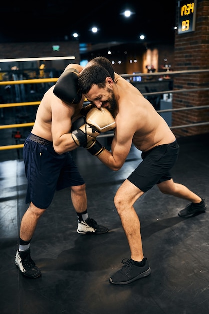 pair of fighters in the ring punching one another in a close distance