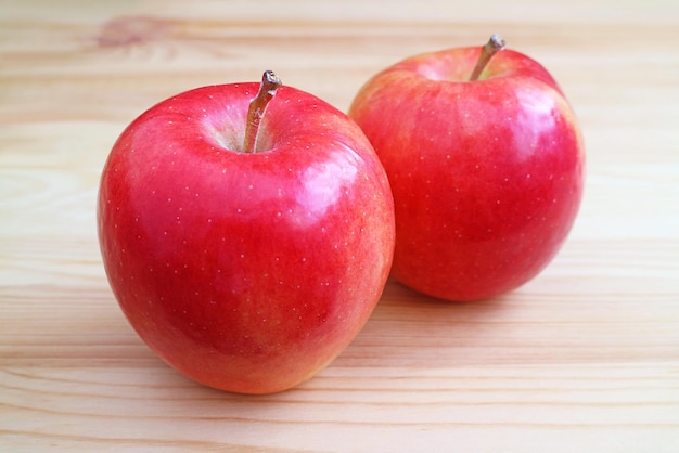 Pair of fresh ripe red apple isolated on wooden table