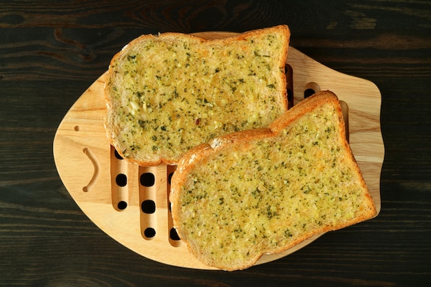 Pair of Garlic Butter Toasts on Wooden Plate Served on Dark 