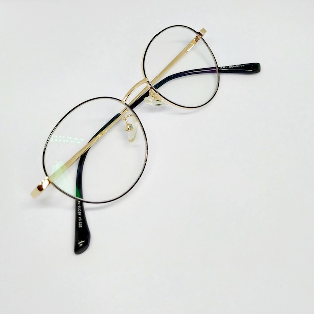 A pair of glasses with gold and black frames with gold trim and black and white letters.