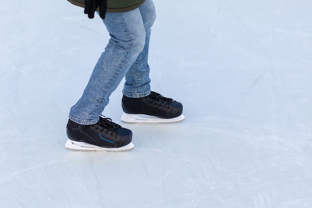 A pair of hockey skates with laces on frozen ice closeup