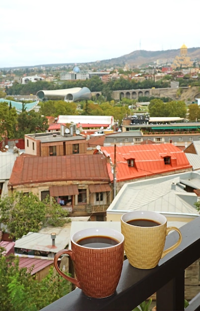 Pair of Hot Coffee on the Balcony Railing with Amazing Tbilisi Aerial View in Backdrop