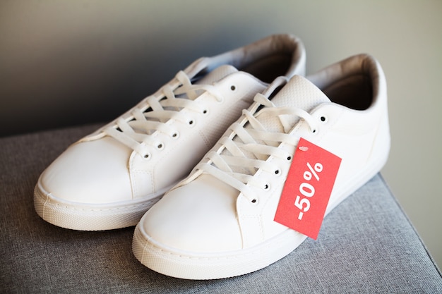 Pair of new stylish white sneakers with discount on gray 