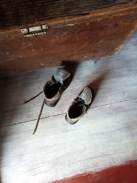 Pair of old brown shoes on wooden floor shoe retro box next to them Top view Natural light