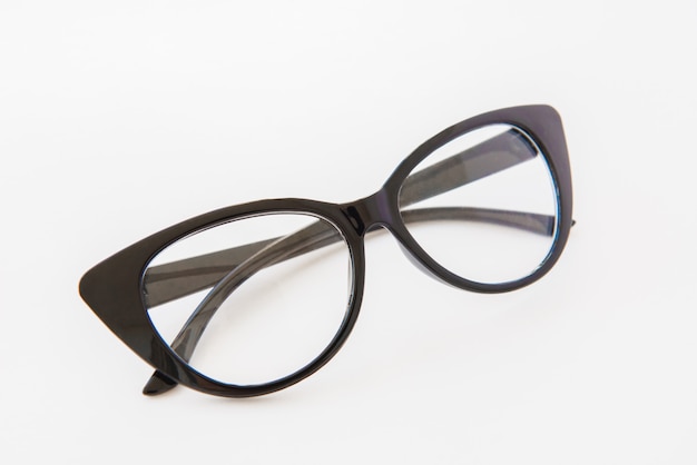 Pair of reading glasses or spectacles with modern dark frames folded up on white