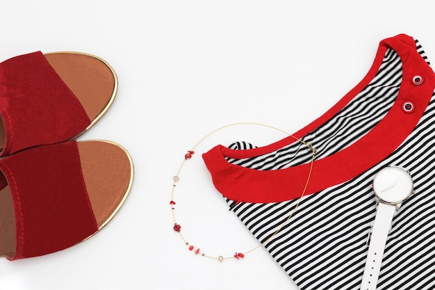 A pair of red and black sandals with a gold necklace and a necklace.