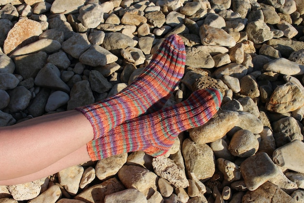 A pair of socks on a beach with a rock background.