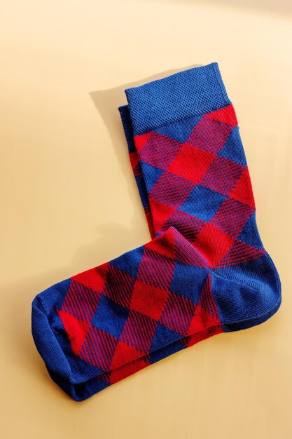 A pair of socks Red and blue checkered socks on a beige background