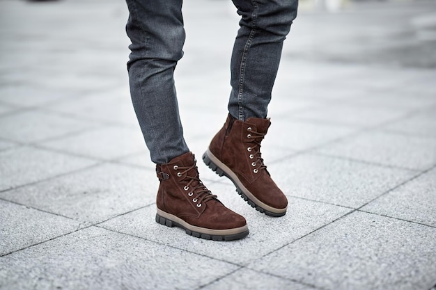 Photo a pair of stylish dark brown leather boots paired with grey denim jeans captures the essence of modern urban fashion