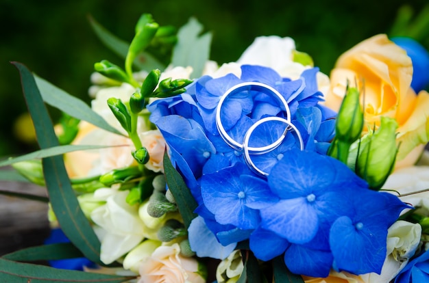 Pair of wedding rings on bridal bouquet