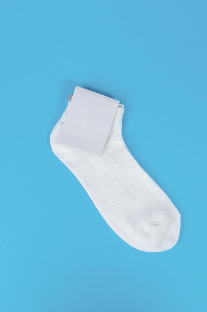 Photo pair of white socks with blank labels on blue background mock up with blank label