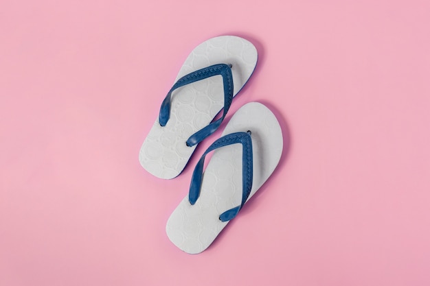 A pairs of white sandal on light pink background