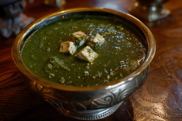 Palak paneer in a brass serving bowl