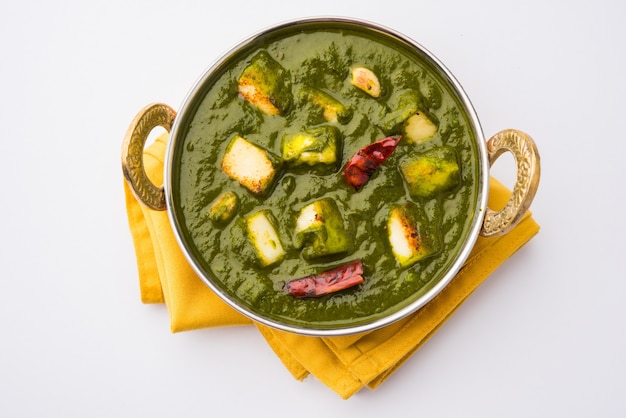 Palak Paneer Curry made up of spinach and cottage cheese, Popular Indian healthy Lunch or Dinner food menu, served in a Karahi with Roti Or Chapati over moody background. selective focus