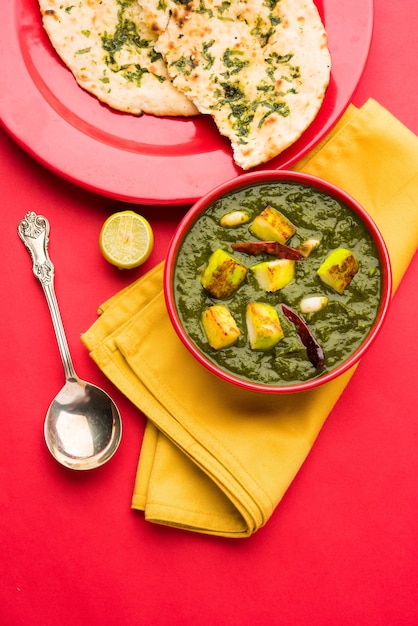 Palak Paneer Curry made up of spinach and cottage cheese, Popular Indian healthy Lunch or Dinner food menu, served in a Karahi with Roti Or Chapati over moody background. selective focus