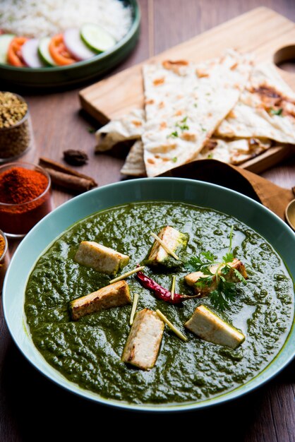 Palak Paneer Masala is a popular North Indian recipe for lunch dinner made using cottage cheese in green spinach curry. usually served with Rice and chapati naan. selective focus