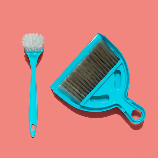 A pale blue dustpan, brush and brush for dish washing