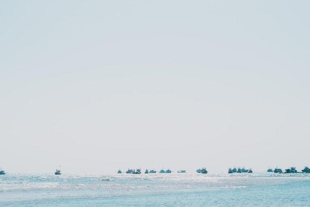 Pale blue gray tone seascape clear sky view Real nature beauty background boats sail skyline bay calm ripple sea Fishing life style trip leisure travel Paradise tranquility serenity peace quiet