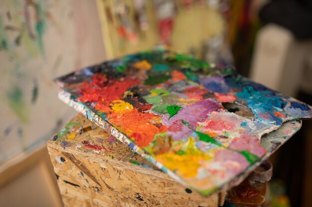 Palette with gouache. Close up of palette with bright colorful gouache of artist lying on drawer