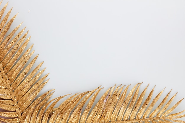 Palm gold leaf on blue background. Palm leaf, Flat lay and top view.