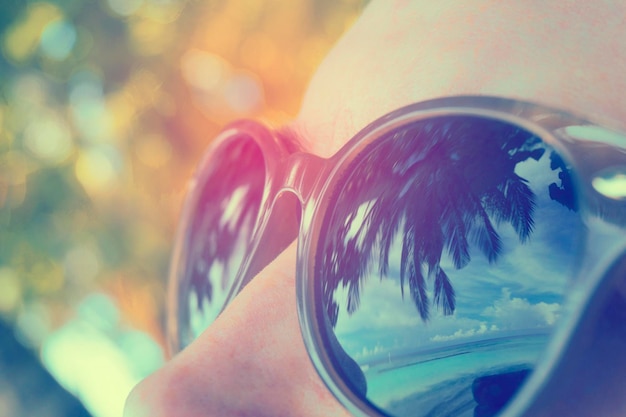 Palm tree reflection in persons sunglasses