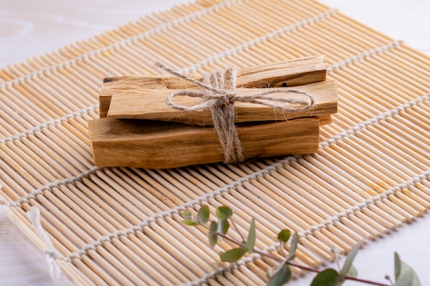 Palo Santo wood sticks on bamboo mat with aromatherapy accessories