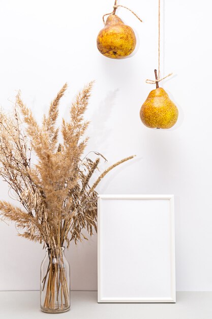 Pampas grass in a glass vase and pears