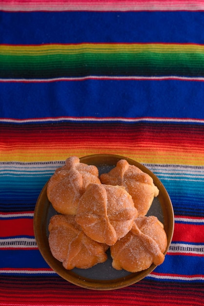 Photo pan de muerto on colorful serape day of the dead celebration