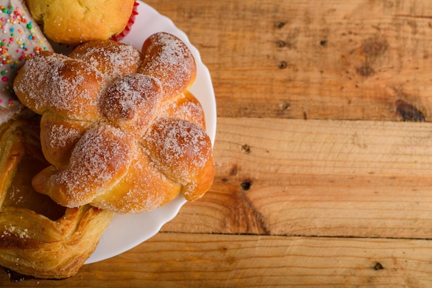 Pan de muerto and other sweet breads on a wooden table Typical Mexican dessert