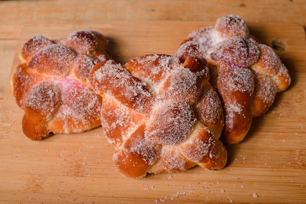 Pan de muertos on a wooden table. Typical Mexican dessert for the Day of the Dead. Top view.