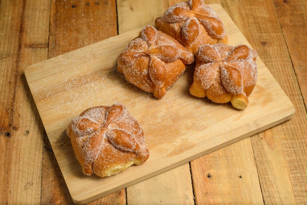 Pan de muertos on a wooden table. Typical Mexican dessert for the Day of the Dead.