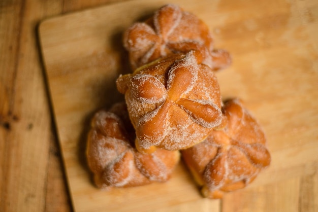 Pan de muertos on a wooden table. Typical Mexican dessert for the Day of the Dead.