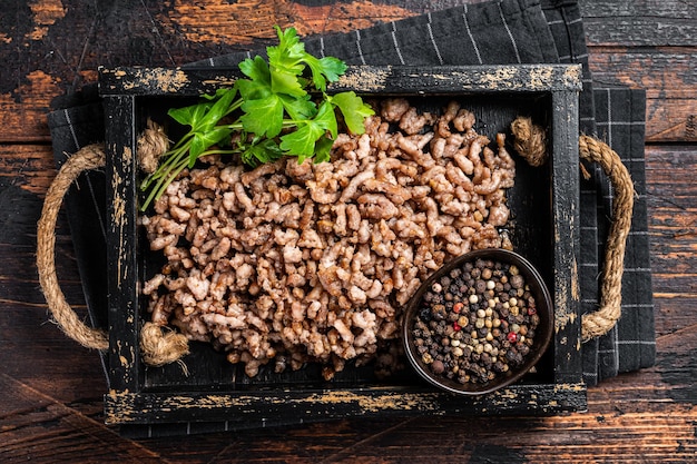 Pan Fried ground beef and lamb meat in a wooden tray with herbs Wooden background Top view