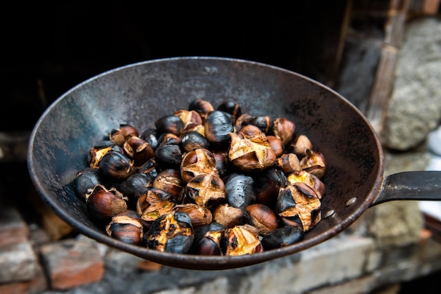 A pan of organic chestnuts grilled on the barbecue