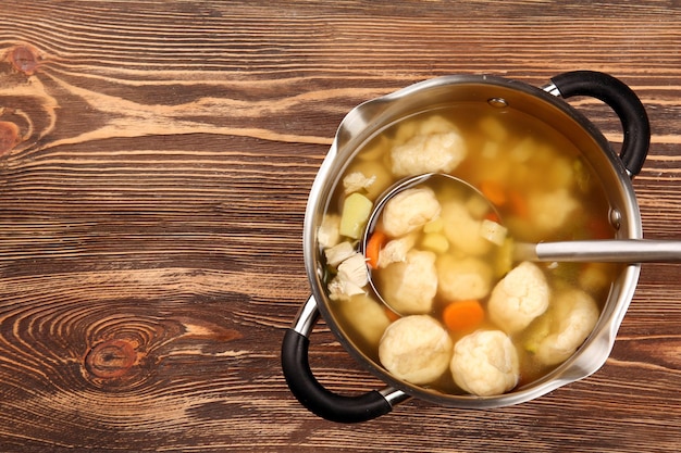 Pan with delicious chicken and dumplings on wooden table