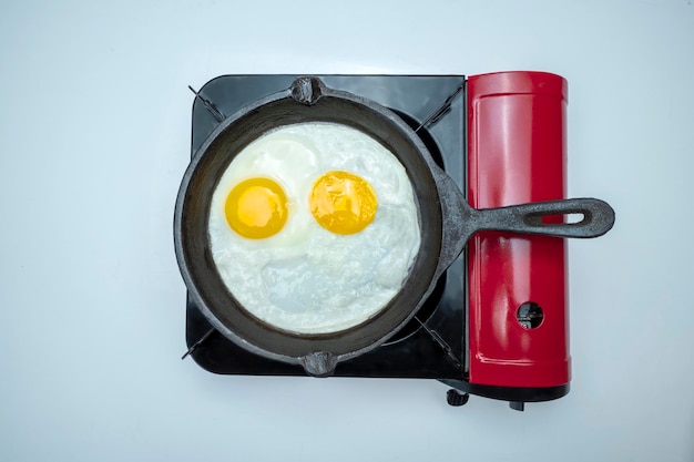 Photo a pan with sunny side up eggs in it on a stove