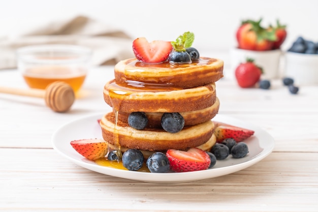 pancake with fresh blueberries, fresh strawberries and honey