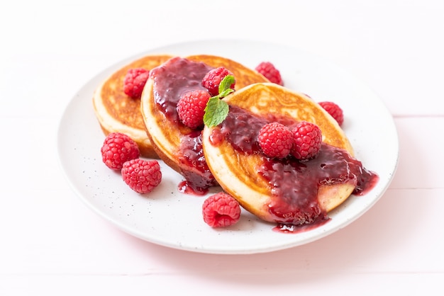 Photo pancake with fresh raspberries and raspberry sauce